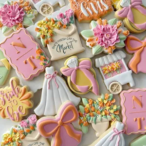 Bridal shower cookie set with a wedding dress, engagement ring, "Miss to Mrs" and "She's Fresh Off the Market" lettering, and a flower cart in blush pink, yellow, and orange.